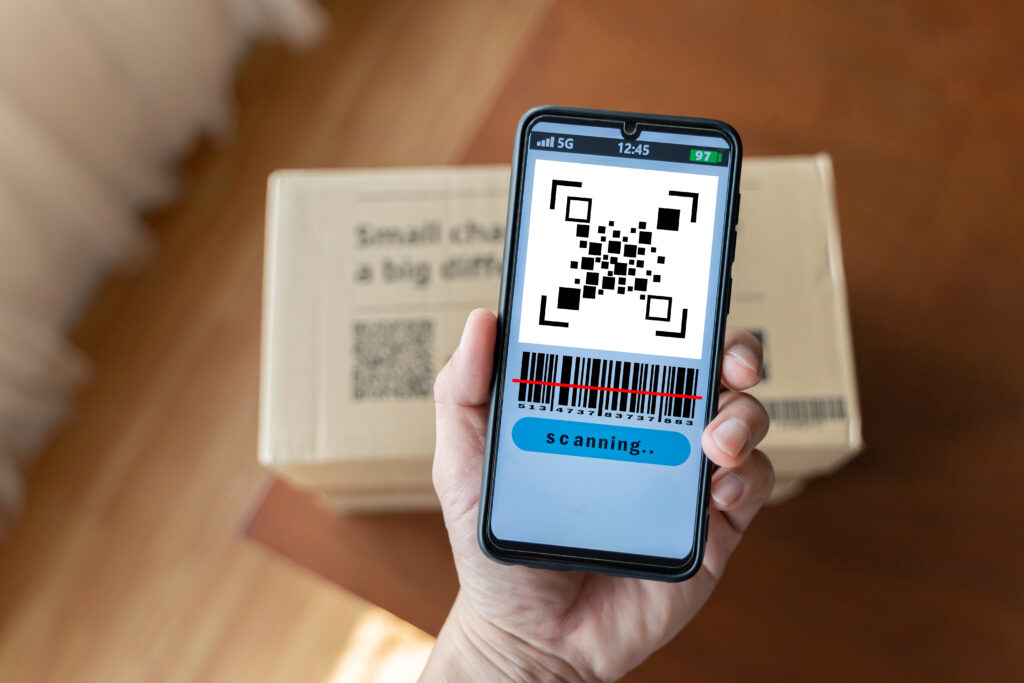 close up of man with smartphone scanning qr code. barcodes on parcels at the post office