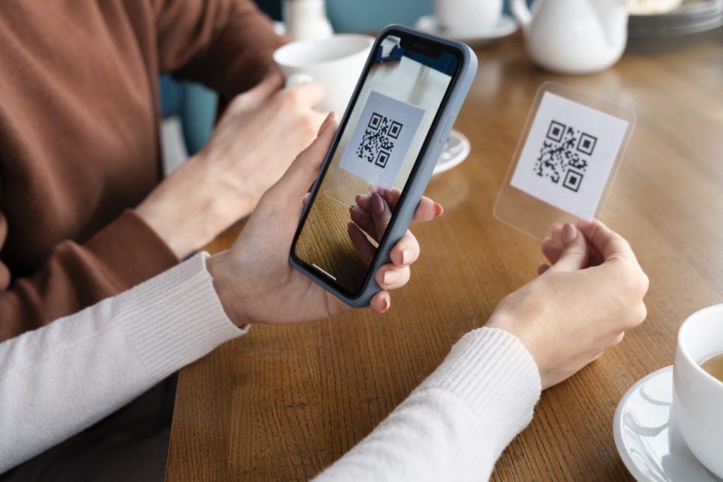close up hands scanning qr code min